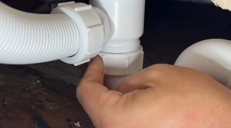 Plumber checking a drain pipe coupling for a hidden leak