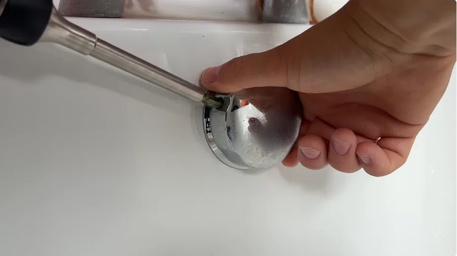 Plumber using a screwdriver on a bathtub overflow fitting