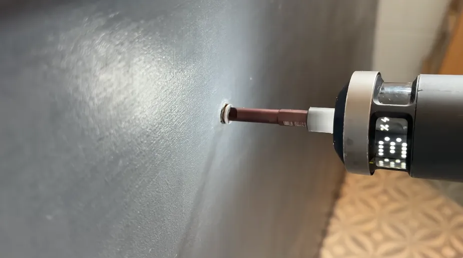 Drilling a small access hole in a bathroom wall panel